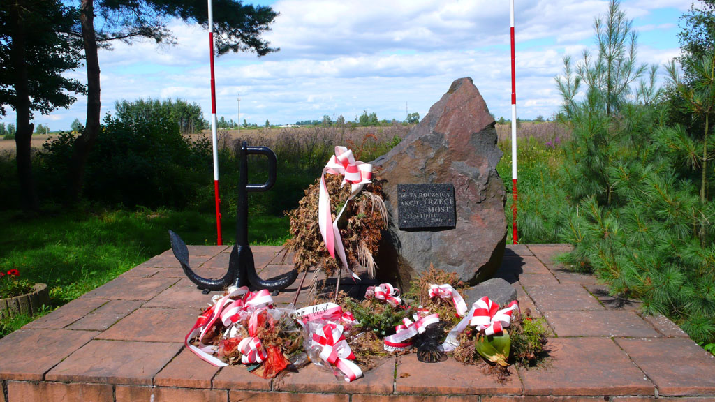 Kliknij, aby powiększyć Pamiątkowy kamień przy drodze nieopodal lądowiska